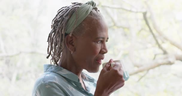 Uma Afro Americana Atenciosa Beber Café Olhar Pela Janela Casa — Vídeo de Stock