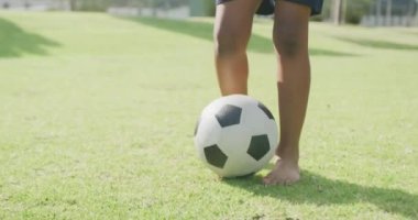 Sahada çıplak ayakla futbol oynayan Afrikalı Amerikalı bir çocuğun videosu. Eğitim, çocukluk, kapsayıcılık, sağlık, spor, ilkokul ve öğrenim kavramı.