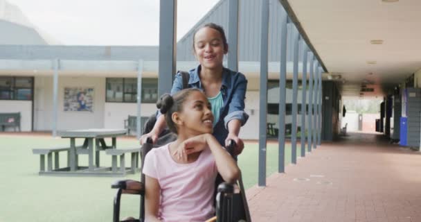 Nagranie Dwóch Szczęśliwych Uczennic Mówiących Szkolnym Korytarzu Jedna Wózku Inwalidzkim — Wideo stockowe