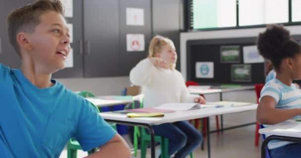 Különböző Boldog Iskolások Ülnek Asztalnál Felemelik Kezüket Iskolában Oktatás Inkluzivitás — Stock videók