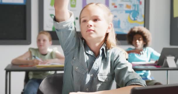 Video Innokas Valkoihoinen Koulutyttö Pöydällä Nostamalla Käsi Vastaamalla Monipuolisessa Luokassa — kuvapankkivideo