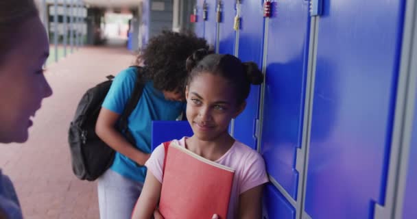 学校の廊下でロッカーが話す2人の多様で幸せな女子生徒のビデオ コピースペース 幼少期 小学校 学習コンセプト — ストック動画