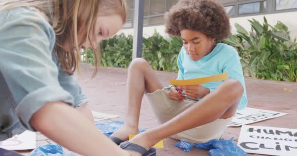 多様な男の子と女の子が学校の庭で抗議プラカードを作るビデオ コピースペース 幼少期 創造性 エコロジー 小学校 学習コンセプト — ストック動画