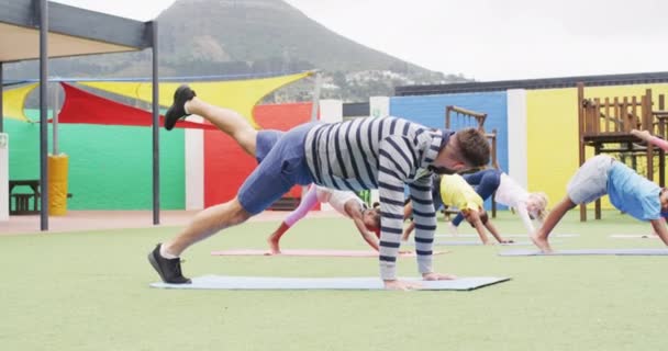 Professora Masculina Diversa Alunos Felizes Exercitando Tapetes Playground Escola Educação — Vídeo de Stock