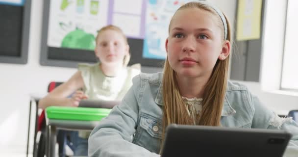 Video Tarkkaavainen Valkoihoinen Koulutyttö Istuu Pöydän Ääressä Kuuntelee Hymyilee Luokassa — kuvapankkivideo