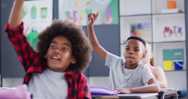 Gelukkige Diverse Schoolkinderen Aan Bureaus Die Elkaars Hand Opsteken Klas — Stockvideo