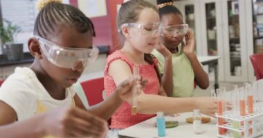 İlkokuldaki kimya sınıfında deneyler yapan farklı okullu kızlar, yavaş çekim. Okul, öğrenim, çocukluk, bilim ve eğitim, değiştirilmemiş.