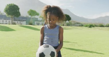 Futbol sahasında futbol oynayan Afrikalı Amerikalı bir kızın video portresi. Eğitim, çocukluk, kapsayıcılık, sağlık, spor, okul ve öğrenim kavramı.