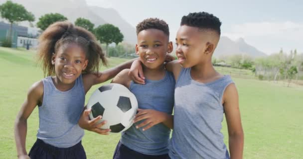 Wideo Trójką Szczęśliwych Afrykańskich Dzieci Trzymających Piłkę Nożną Boisku Szkolnym — Wideo stockowe