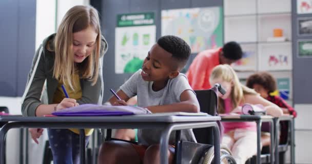 Szczęśliwie Zróżnicowanych Uczniów Przy Biurkach Piszących Klasie Szkolnej Edukacja Dzieciństwo — Wideo stockowe