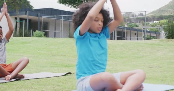 Video Olika Skolflicka Och Skolpojke Praktiserar Yoga Meditation Utomhus Klass — Stockvideo