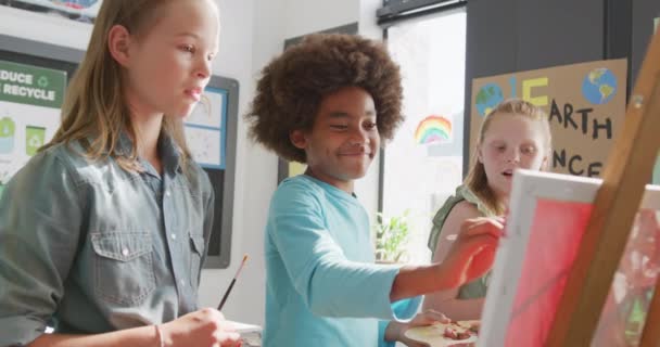 Wideo Różnorodnych Szczęśliwych Uczniów Stojących Sztalugach Malujących Mówiących Klasie Plastycznej — Wideo stockowe
