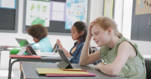 Video Turhautunut Valkoihoinen Koulutyttö Istuu Pöydällä Käyttäen Tabletti Eri Luokassa — kuvapankkivideo