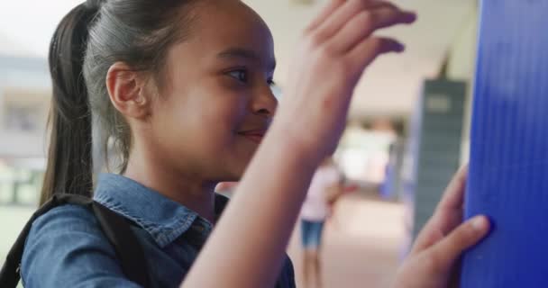 Video Muotokuva Onnellinen Biracial Koulutyttö Käyttäen Kaappi Hymyillen Koulun Käytävällä — kuvapankkivideo