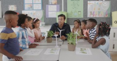 İlkokulda ekoloji sınıfında çeşitli erkek öğretmenler ve rüzgar türbinleri olan çocuklar, yavaş çekim. Okul, öğrenme, çocukluk, ekoloji, farkındalık, öğretim ve eğitim, değiştirilmemiş.