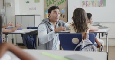 İlkokulda masa başında kızla konuşan çeşitli erkek öğretmenler var. Ağır çekimde. Okul, öğrenme, çocukluk, öğretim ve eğitim, değiştirilmemiş.