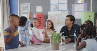 İlkokulda ekoloji sınıfında çeşitli erkek öğretmenler ve rüzgar türbinleri olan çocuklar, yavaş çekim. Okul, öğrenme, çocukluk, ekoloji, farkındalık, öğretim ve eğitim, değiştirilmemiş.