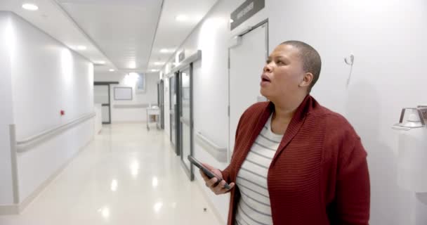 Stressed African American Woman Using Smartphone Hospital Corridor Slow Motion — Vídeos de Stock
