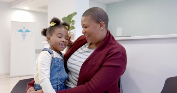 Feliz Madre Afroamericana Sosteniendo Hija Rodillas Sala Espera Del Hospital — Vídeos de Stock