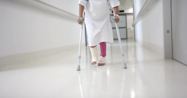 Lowsection African American Girl Hospital Gown Walking Using Crutches Corridor — Stockvideo