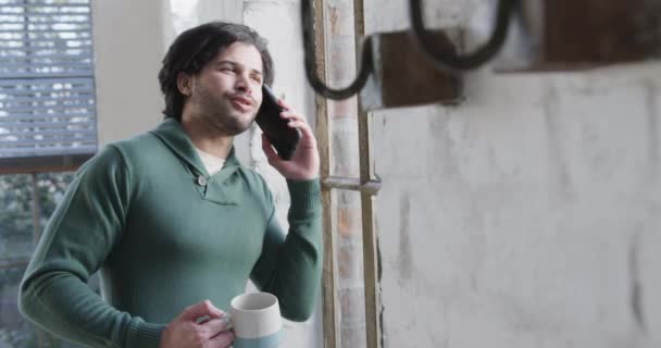 Homem Caucasiano Bebendo Café Falando Smartphone Olhando Pela Janela Casa — Vídeo de Stock