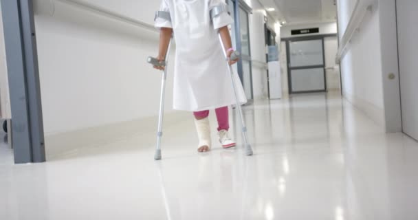 Lowsection African American Girl Hospital Gown Walking Using Crutches Corridor — стокове відео
