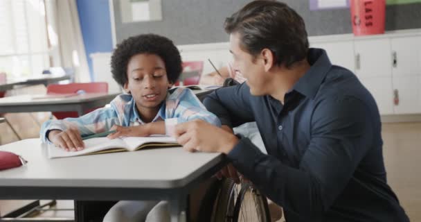 Щасливий Різноманітний Вчитель Чоловічої Статі Хлопчик Інвалідному Візку Розмовляє Уроках — стокове відео