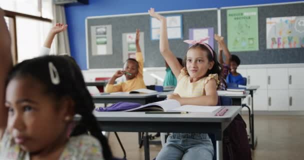 Lykkelige Mangfoldige Skolebarn Skrivebordet Løfter Hender Grunnskoleklasserommet Sakte Bevegelse Skole – stockvideo