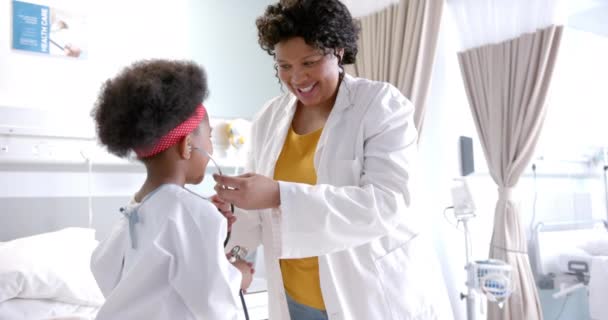 ハッピー アフリカ系アメリカ人女性医師が病院の部屋で女の子をだまし ゆっくり動く 医療サービス 小児期および病院 変更されていない — ストック動画
