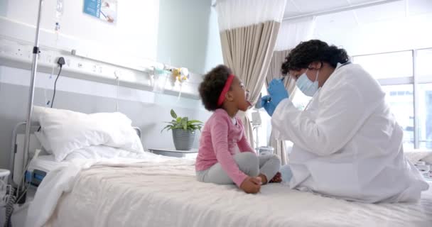 African American Female Doctor Face Mask Examining Throat Girl Hospital — Vídeo de stock