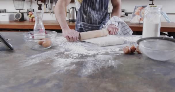 台所でタブレットを使用してパン生地を準備する白人男性の中央部 スローモーション 健康的なライフスタイル レシピと国内生活 変更なし — ストック動画