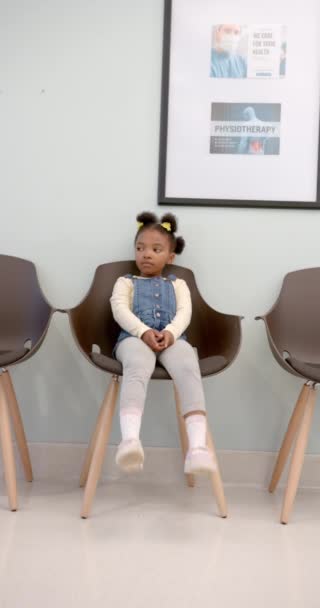 Vertical Video African American Girl Sitting Chair Hospital Corridor Medical — Wideo stockowe