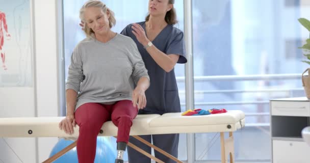 Caucasian Female Physiotherapist Stretching Neck Female Senior Patient Rehab Center — Stok video