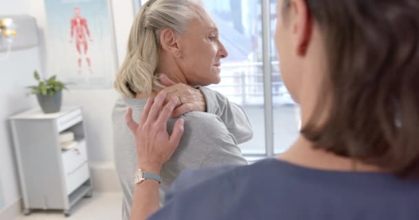 Caucasian Female Physiotherapist Massaging Back Female Senior Patient Rehab Center — Video