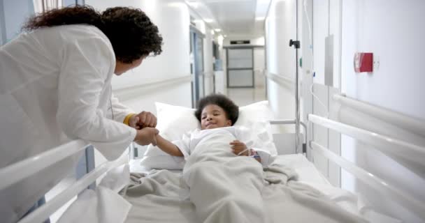 African American Female Doctor Holding Hand Girl Lying Hospital Bed — Stockvideo