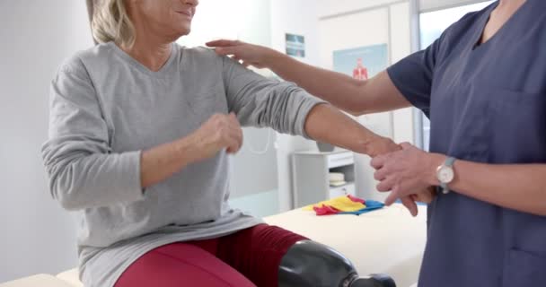 Caucasian Female Physiotherapist Stretching Hand Female Senior Patient Rehab Center — Αρχείο Βίντεο