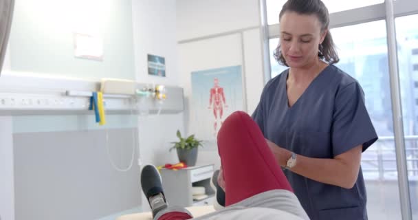 Caucasian Female Physiotherapist Stretching Leg Female Patient Rehab Center Bionic — Wideo stockowe