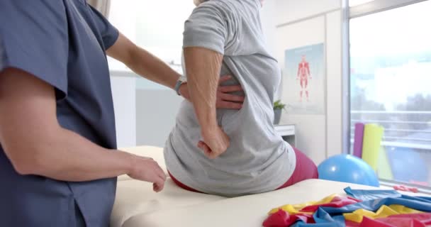 Caucasian Female Physiotherapist Massaging Lower Back Female Senior Patient Rehab — Vídeos de Stock
