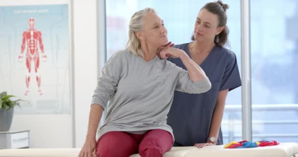 Caucasian Female Physiotherapist Stretching Neck Female Senior Patient Rehab Center — Stockvideo