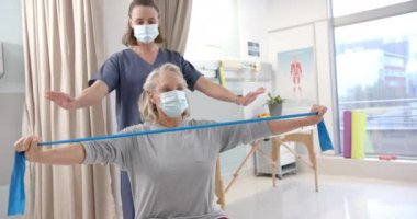 Caucasian female physiotherapist and female senior patient with prosthetic leg exercising. Prosthetics, physiotherapy rehabilitation and medical healthcare concept