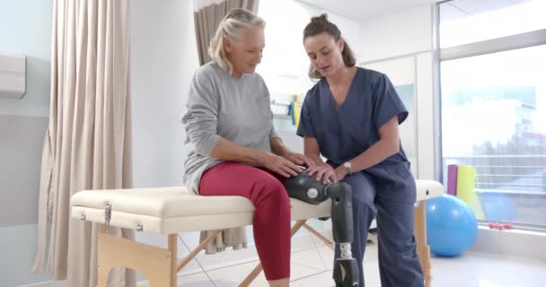 Caucasian Female Physiotherapist Stretching Prosthetic Leg Female Patient Rehab Center — Stok video