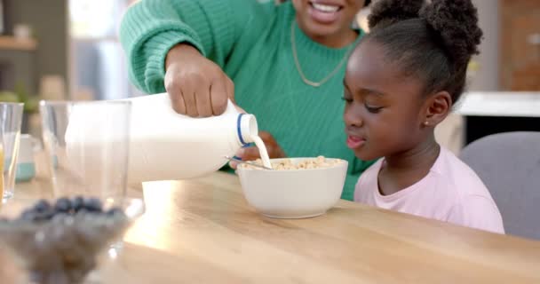 Szczęśliwa Afrykańska Matka Wylewa Mleko Płatki Córką Kuchni Zwolnione Tempo — Wideo stockowe