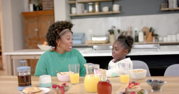 African American Mother Daughter Eating Cereal Milk Talking Kitchen Slow — ストック動画