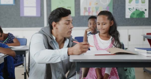 Glad Varierad Manlig Lärare Hjälper Skolbarn Att Skriva Klassrummet Grundskolan — Stockvideo