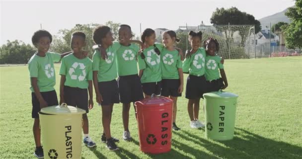 Portret Szczęśliwych Zróżnicowanych Uczniów Koszami Śmieci Boisku Sportowym Szkole Podstawowej — Wideo stockowe