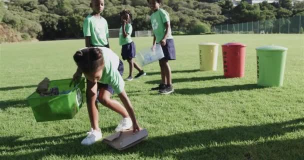Щасливі Різноманітні Школярі Носили Футболки Переробки Прибираючи Спортивне Поле Початковій — стокове відео