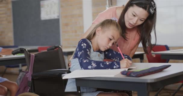 초등학교에서 교실에서 휠체어에서 여학생을 가르치는 선생님 변함없는 — 비디오