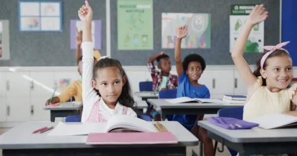 小学校で教室で手を挙げる机で 多様な子供たちが幸せに暮らしています 変更されていない — ストック動画