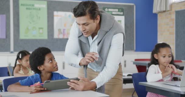 Szczęśliwy Zróżnicowany Nauczyciel Pomaga Uczniom Korzystającym Tabletu Szkole Podstawowej Szkoła — Wideo stockowe