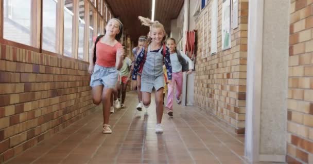 Ευτυχισμένες Διαφορετικές Μαθήτριες Σχολικές Τσάντες Τρέχουν Στο Διάδρομο Του Δημοτικού — Αρχείο Βίντεο